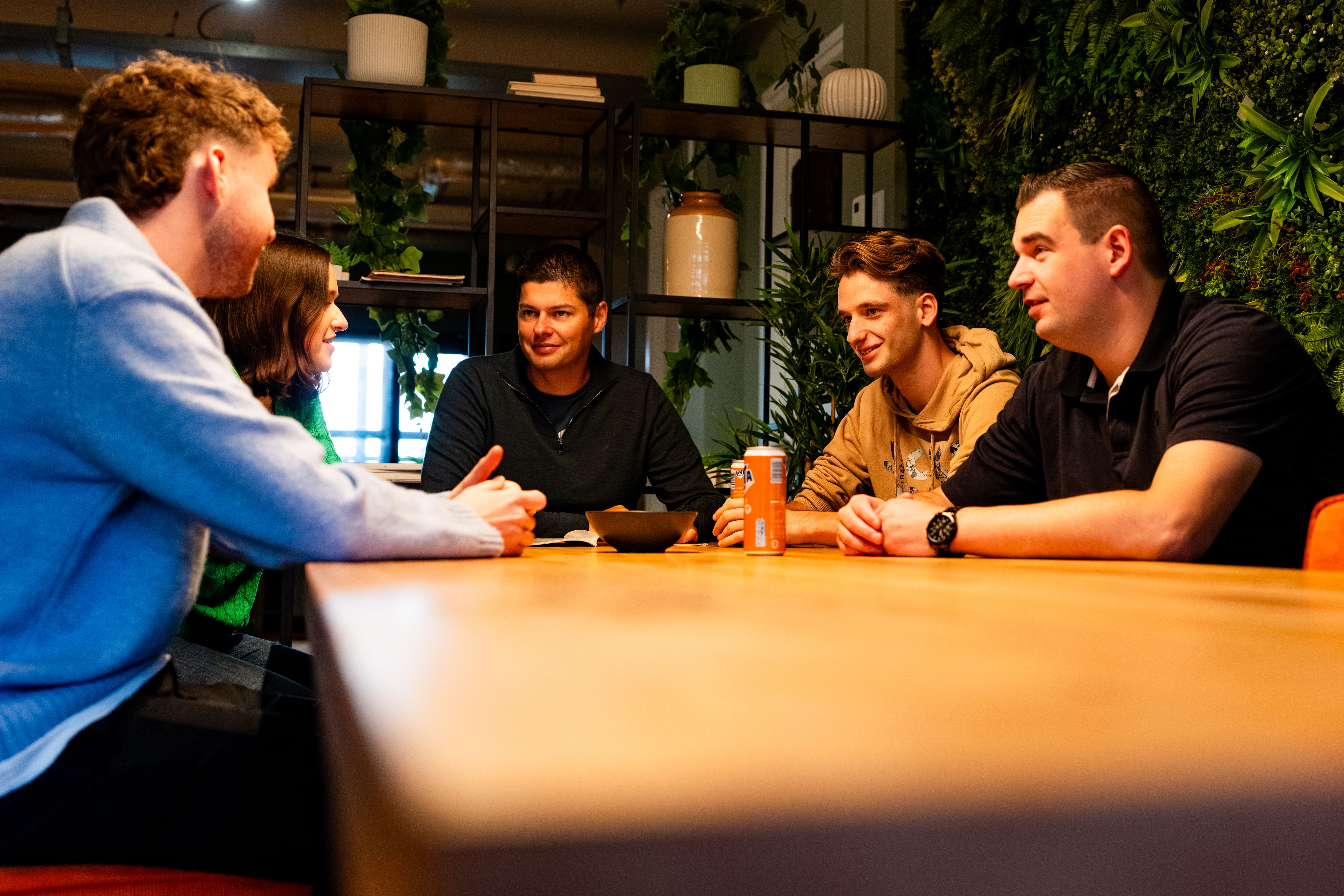 Team van Blauwtand aan een bruine tafel